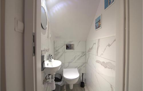 Baño blanco con lavabo y aseo en 2 Bedroom Beautiful Home In Czarny Mlyn, en Czarny Młyn