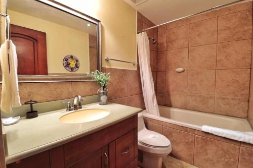 a bathroom with a sink and a toilet and a mirror at Suite San Juan 125 Gran Pacifica Resort in San Diego