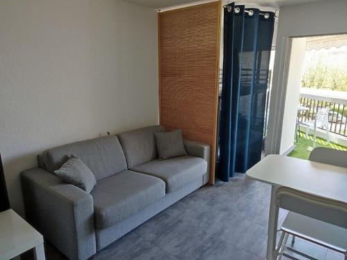un salon avec un canapé et une fenêtre dans l'établissement Beau studio lumineux climatisé Classé 2 Etoiles, à 130 m des plages, à La Grande Motte