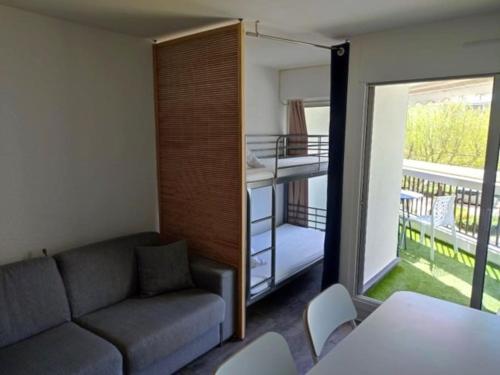 d'un salon avec un canapé et un balcon. dans l'établissement Beau studio lumineux climatisé Classé 2 Etoiles, à 130 m des plages, à La Grande Motte