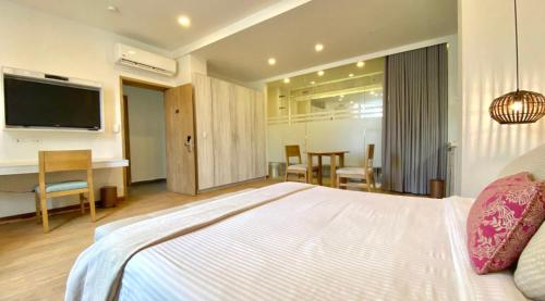 um quarto com uma grande cama branca e uma televisão em Beautiful 1BR Suite 105 em Cartagena das Índias