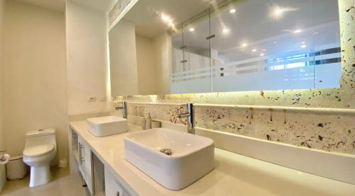 a white bathroom with a sink and a toilet at Beautiful 1BR Suite 105 in Cartagena de Indias