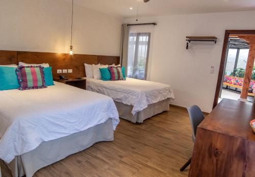 a hotel room with two beds and a table at Hotel Las Camelias Inn by AHS in Antigua Guatemala