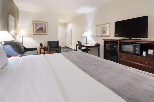 a hotel room with a large bed and a flat screen tv at Best Western Comanche Inn in Comanche
