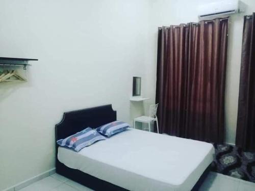 大港的住宿－Homestay Dorani Sungai Besar，卧室配有白色的床和窗户。