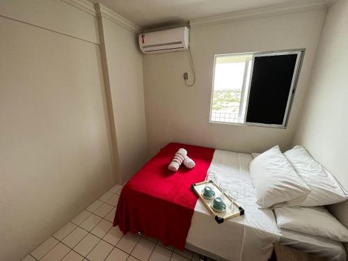 ein kleines Schlafzimmer mit einem Bett mit einer roten Decke in der Unterkunft Lindo Flat Verde Mar em São José da Coroa Grande, Pernambuco in São José da Coroa Grande