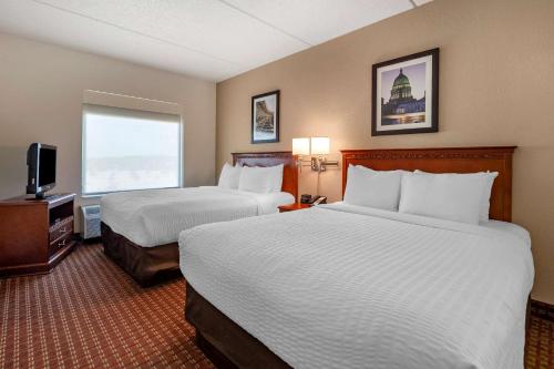 a hotel room with two beds and a television at Clarion Suites at the Alliant Energy Center in Madison