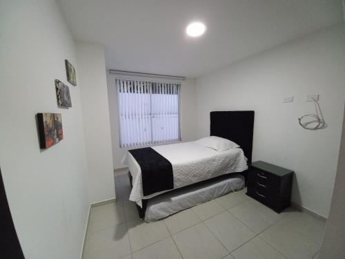 a small bedroom with a bed and a window at Apartamento amoblado en la Francia in Manizales