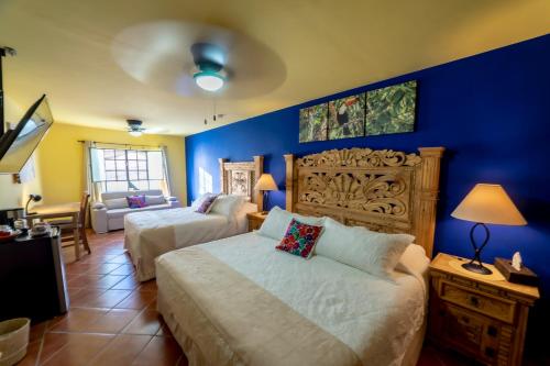 - une chambre avec 2 lits et un mur bleu dans l'établissement La Casona Chapala, à Chapala