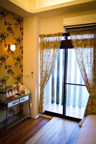 a living room with a large window with curtains at Muho B&B in Dongshan
