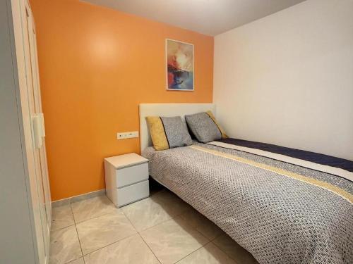 - une chambre avec un lit et un mur orange dans l'établissement GRAND T2 GARE AMIENS TOUT CONFORT 2PERS WIFI, à Amiens