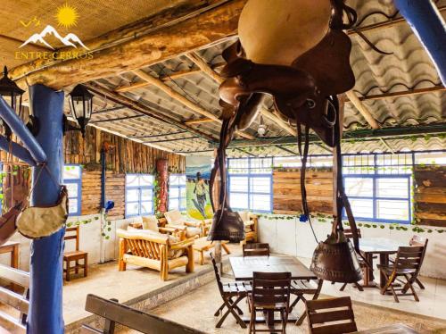 a restaurant with tables and chairs and a cow hanging from the ceiling at Hotel Campestre Entre Cerros in Ubalá