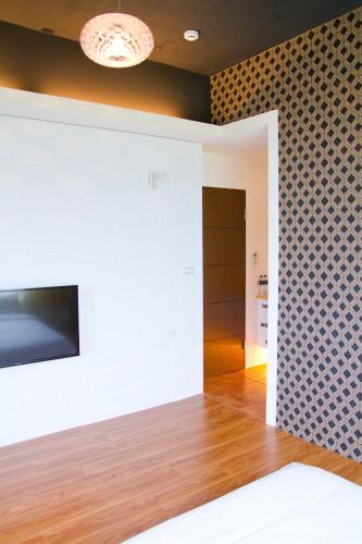 a room with a white wall with a tv on it at Muho B&B in Dongshan