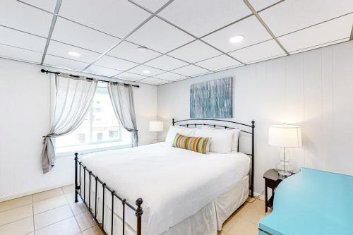 a white bedroom with a bed and a window at Unit 32, Island Retreat Resort in Port Aransas
