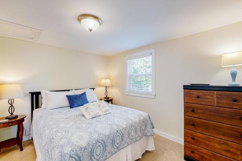 ein Schlafzimmer mit einem Bett, einer Kommode und einem Fenster in der Unterkunft Barrett's Watch Apartment in Boothbay Harbor