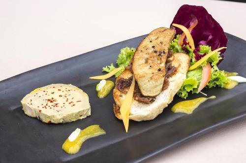 a sandwich and salad on a black plate at The Island Lodge in My Tho