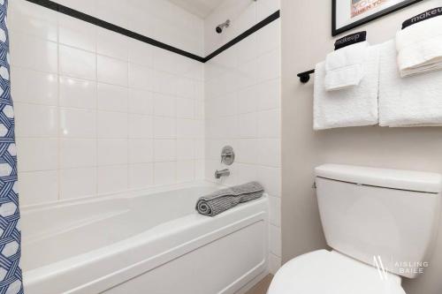 a white bathroom with a tub and a toilet at The Powder Nook, Hot Pools, Mile 1 Express Chair in Panorama