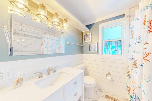 baño con lavabo y aseo y ventana en Fun in the Ocean City Sun en Ocean City