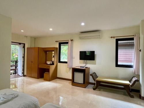 sypialnia z łóżkiem, krzesłem i telewizorem w obiekcie Baantip Suantong w mieście Amphawa
