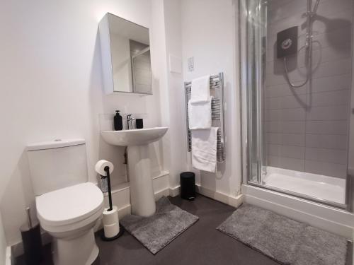 a bathroom with a toilet and a sink and a shower at Large 65 Inch TV Full Kitchen Long-Stay Ready in Liverpool