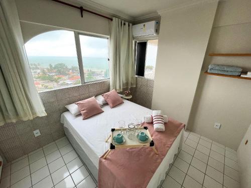 a bedroom with a bed with a large window at Lindo Flat Mar Azul em São José da Coroa Grande, Pernambuco in São José da Coroa Grande