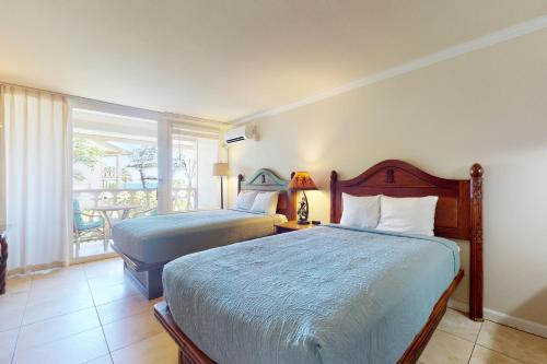 um quarto com 2 camas e uma varanda em Islander on the Beach 211 em Kapaa