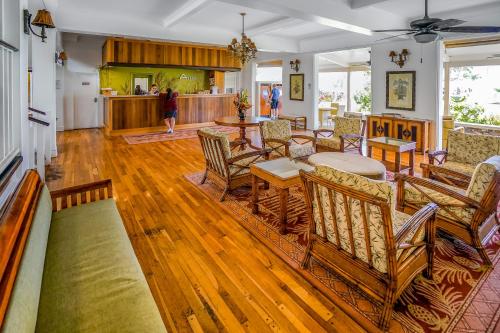 a living room with wooden floors and chairs and a table at Islander on the Beach 211 in Kapaa