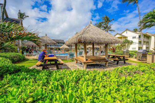 a person sitting at a picnic table at a resort at Islander on the Beach 211 in Kapaa