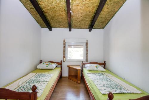 2 Betten in einem kleinen Zimmer mit Fenster in der Unterkunft Apartments and rooms with parking space Biograd na Moru, Biograd - 6219 in Biograd na Moru
