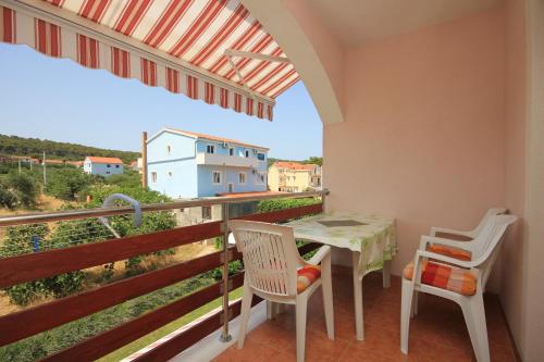 a balcony with a table and chairs and a view at Apartments by the sea Kraj, Pasman - 8247 in Tkon