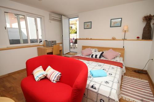 czerwone krzesło i łóżko w pokoju w obiekcie Holiday house with WiFi Kukljica, Ugljan - 8251 w mieście Kukljica