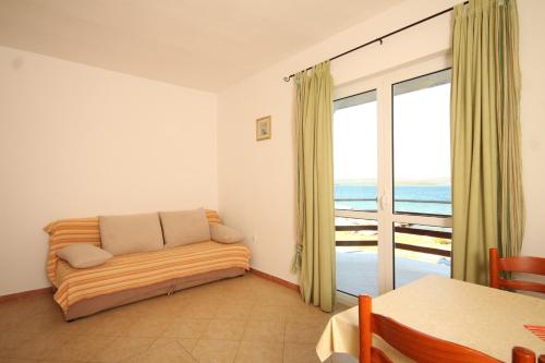 a living room with a couch and a balcony at Apartments by the sea Kraj, Pasman - 8247 in Tkon