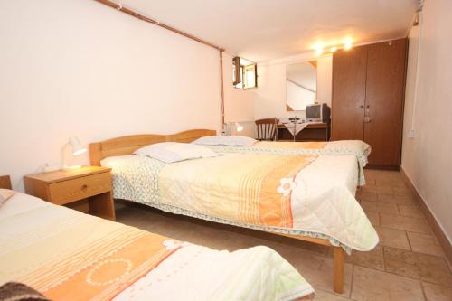 a hotel room with two beds and a desk at Apartments with a parking space Cres - 7984 in Cres