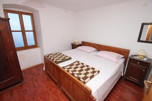 a bedroom with a bed with a checkered blanket on it at Apartments with WiFi Beli, Cres - 8094 in Beli