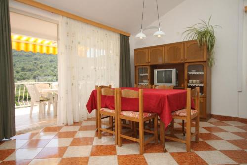 uma sala de jantar com uma mesa vermelha e cadeiras em Apartments and rooms with parking space Bozava, Dugi otok - 8100 em Božava