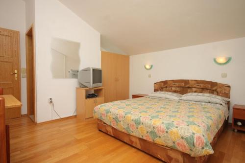 a bedroom with a bed and a television in it at Apartments and rooms with parking space Bozava, Dugi otok - 8100 in Božava