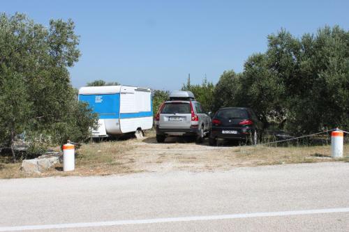 two cars parked next to a trailer and a truck at Apartment Bozava 8100a in Božava