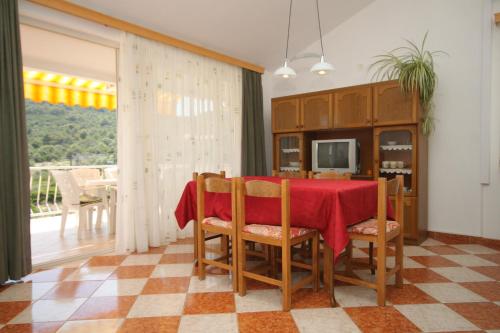 a dining room with a red table and chairs at Apartment Bozava 8100a in Božava