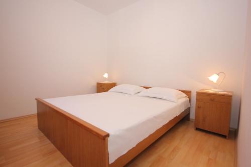 una camera con un letto e due comodini con lampade di Seaside holiday house Cove Rogacic, Vis - 8889 a Vis