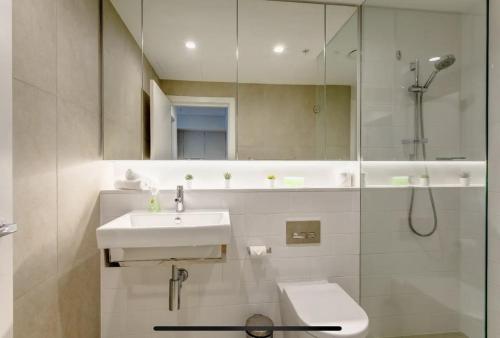 a bathroom with a sink and a shower and a toilet at Lovely One Bedroom + Study with Infinity Pool in Sydney