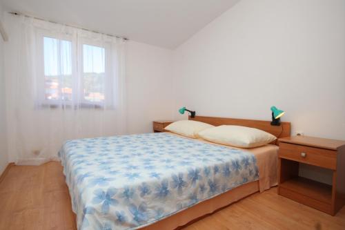- une chambre dotée d'un lit avec une couverture bleue et blanche dans l'établissement Apartment Preko 8384c, à Preko