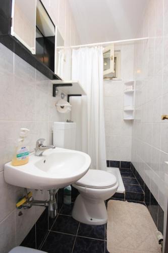 a white bathroom with a sink and a toilet at Double Room Medveja 2305a in Lovran