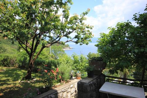 a garden with a bench and a view of the ocean at Apartments and rooms by the sea Medveja, Opatija - 2305 in Lovran