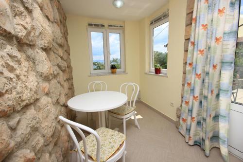 a room with a table and chairs and windows at Apartments and rooms by the sea Medveja, Opatija - 2305 in Lovran
