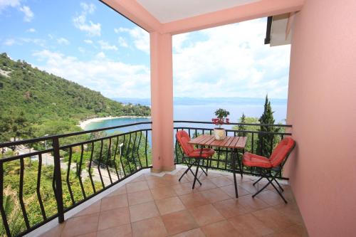 a balcony with a table and chairs and a view of the ocean at Apartments and rooms by the sea Medveja, Opatija - 2305 in Lovran