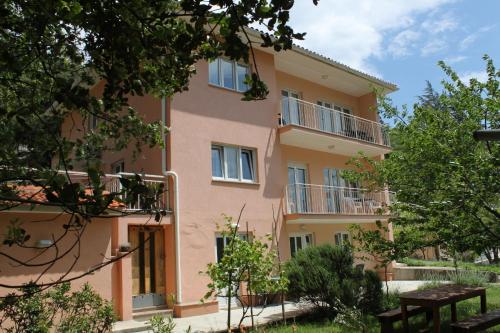 een appartementencomplex met balkons en bomen bij Apartment Moscenicka Draga 2327c in Mošćenička Draga