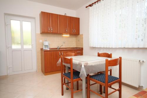 een keuken met een tafel en stoelen en een raam bij Apartment Moscenicka Draga 2327c in Mošćenička Draga