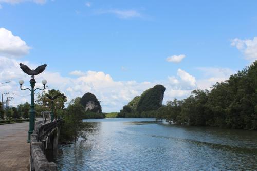a river with a bird sitting on a street light at Grand Mansion Hotel in Krabi town