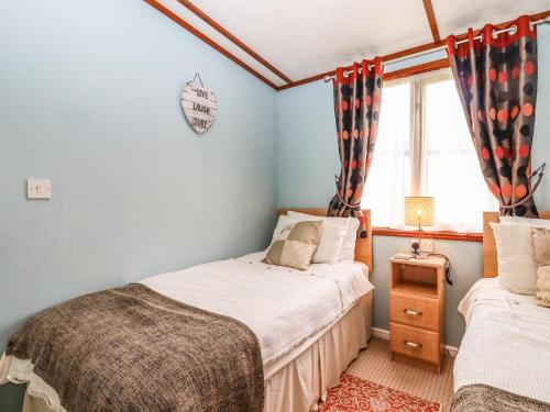 a bedroom with two beds and a window at Lodge Two, Country View Park in Faversham