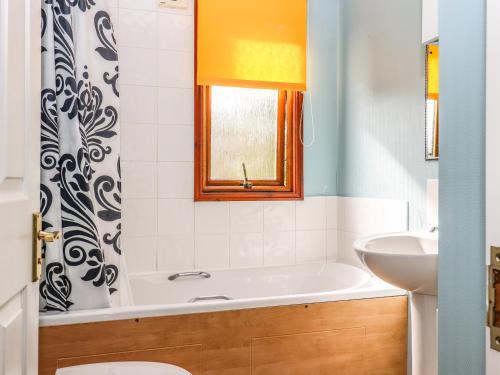 a bathroom with a tub and a sink at Lodge Two, Country View Park in Faversham